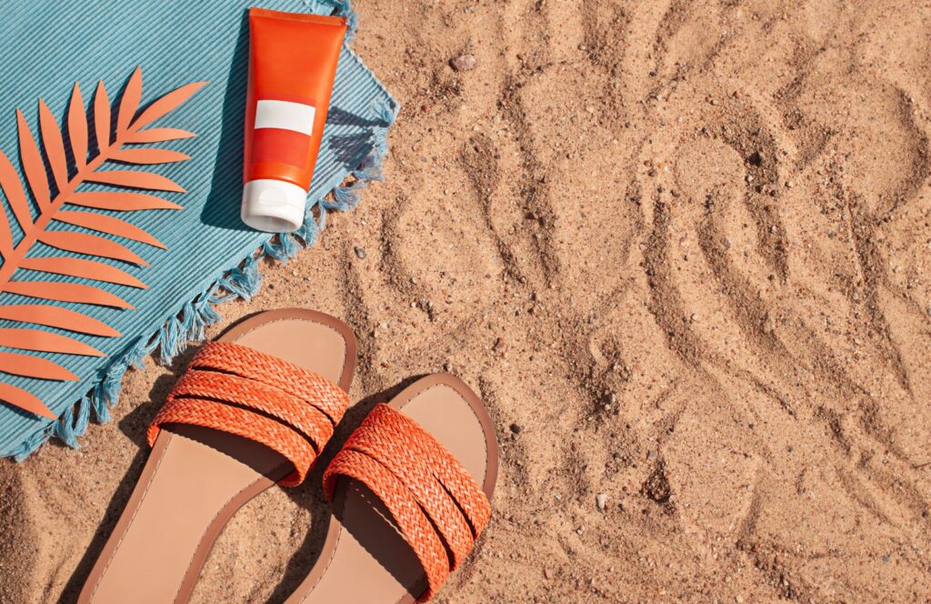 Oranžinės šlepetės ant smėlio
